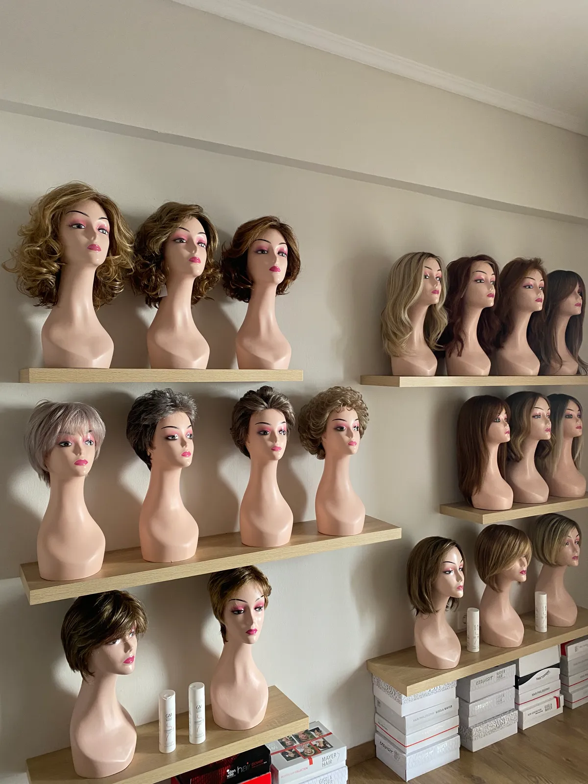 Ράφια με περούκες σε κεφαλές στο showroom της TRESSE